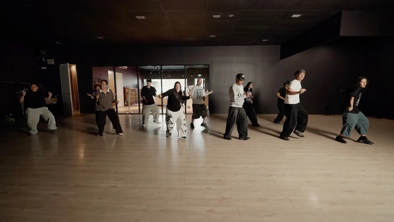Dancers rehearsing together across a wide studio floor
